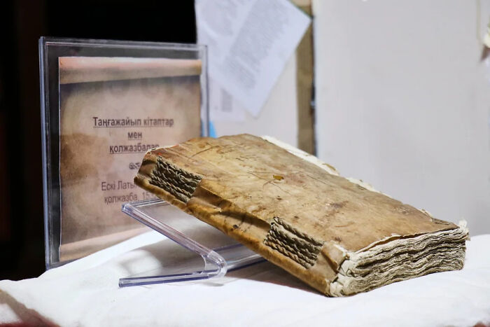 Ancient worn book on display stand, symbolizing mysterious events and urban myths lost to time and unknown truth.