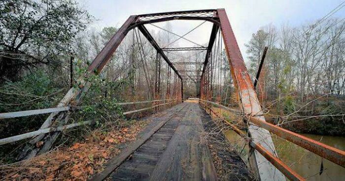 Rusty abandoned metal bridge in a forest setting representing mysterious events and urban myths in a haunting atmosphere.