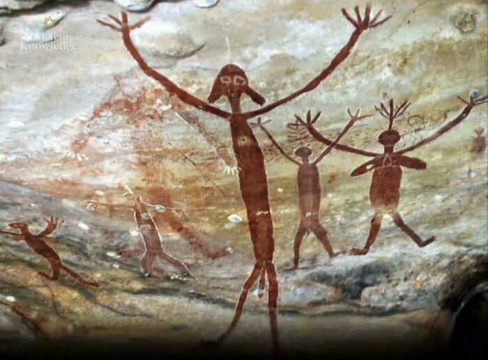 Ancient cave painting depicting mysterious figures with raised arms, representing enigmatic events and urban myths.
