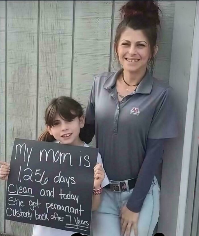 Young girl holding a positive message about her mom's recovery and custody, inspiring heartwarming posts for much-needed positivity.