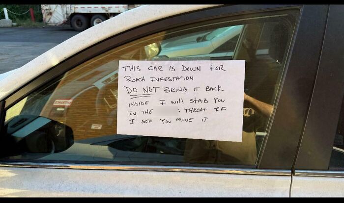 Car mechanic note on a vehicle window warning about roach infestation and not to move the car.