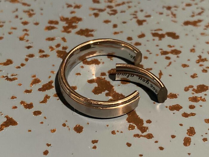 Broken gold wedding ring lying on a spotted surface, illustrating trashy and tacky wedding stories.