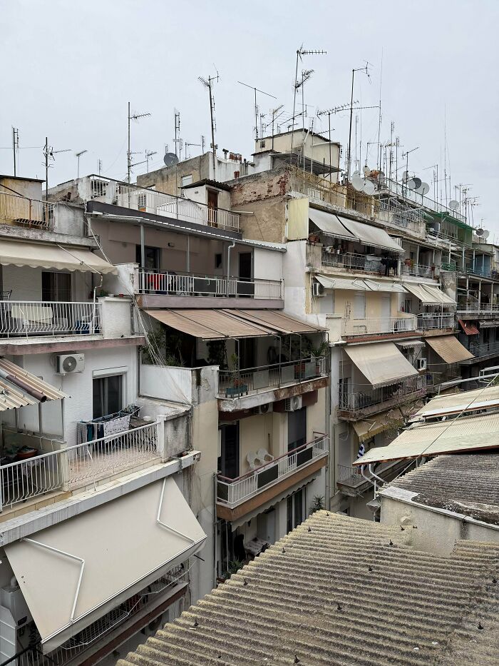 Urban hell apartment buildings with numerous antennas on rooftops under gray sky