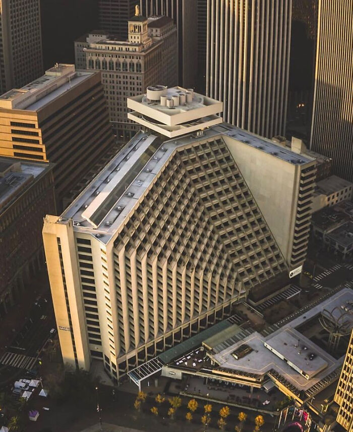 Modern pyramid-shaped office building towering in urban hell cityscape