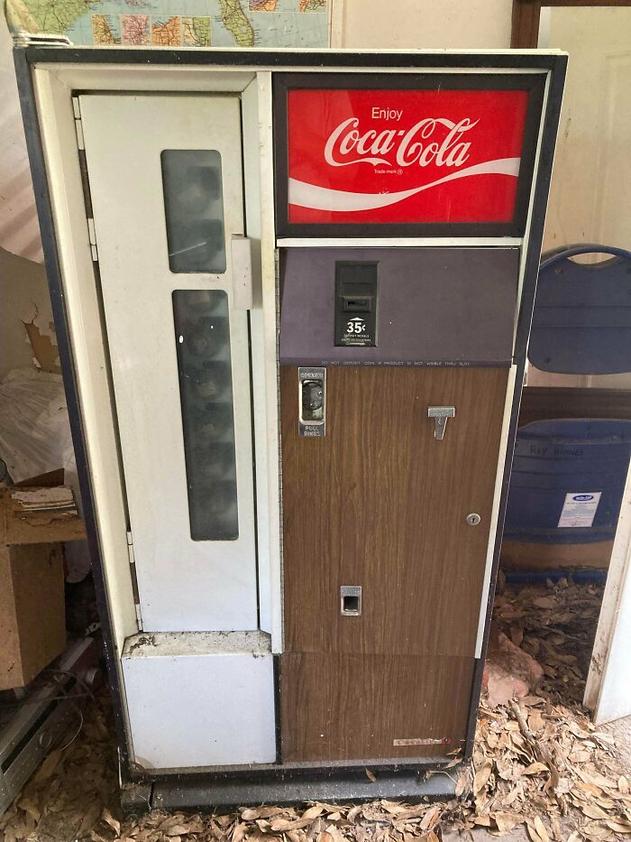 An old Coca-Cola vending machine, faded and dusty, with a 35-cent coin slot, showcasing unusual possessions.