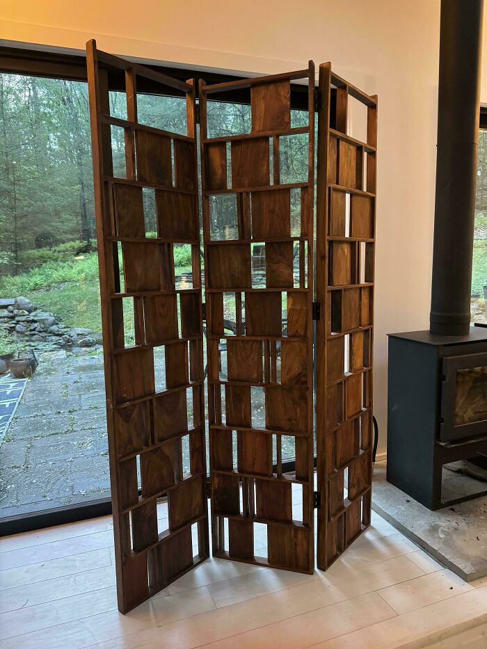 A unique, dark wood room divider with a geometric pattern, showcasing the true value of unusual possessions.