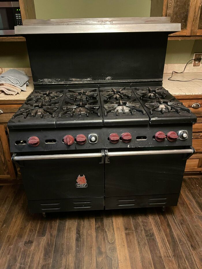 A large black Wolf range with six burners and red knobs. An unusual possession with true value.