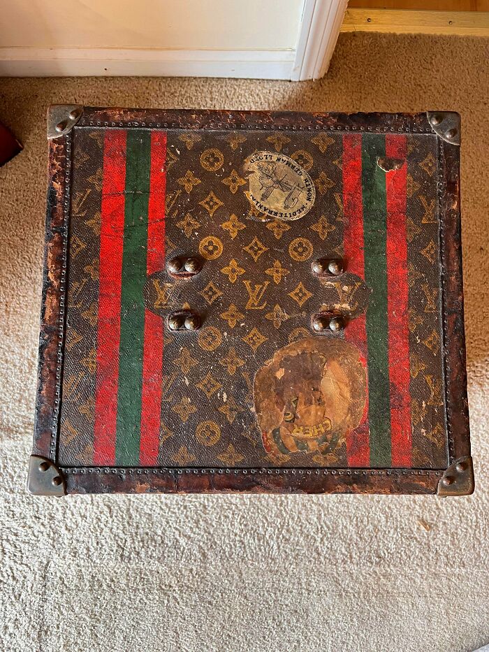 A vintage Louis Vuitton trunk with red and green stripes, worn with travel stickers. An unusual possession with true value.