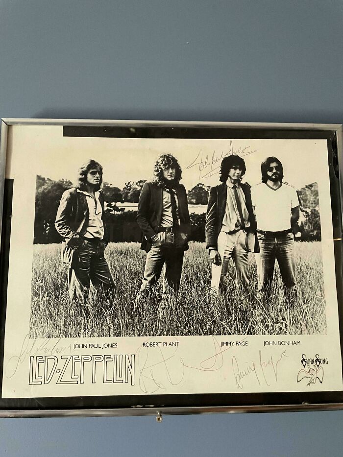 Framed black and white photo of Led Zeppelin in a field, autographed, an unusual possession with true value.