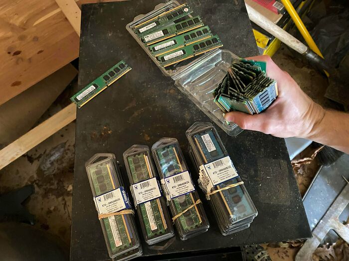 A hand holding a stack of computer RAM sticks, surrounded by more RAM in packaging. The Internet helped understand the true value of these unusual possessions.