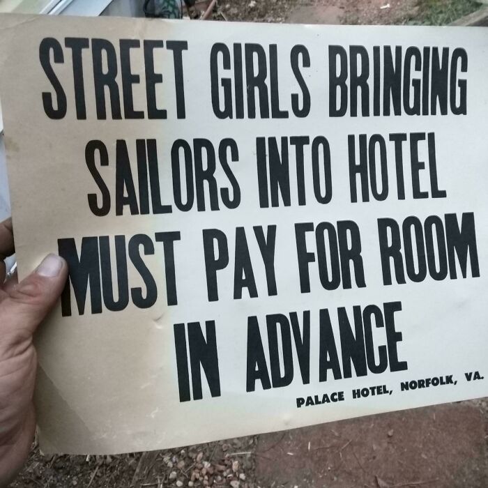 A hand holding up an old Palace Hotel sign, showing the unusual possession of a historic hotel rule.