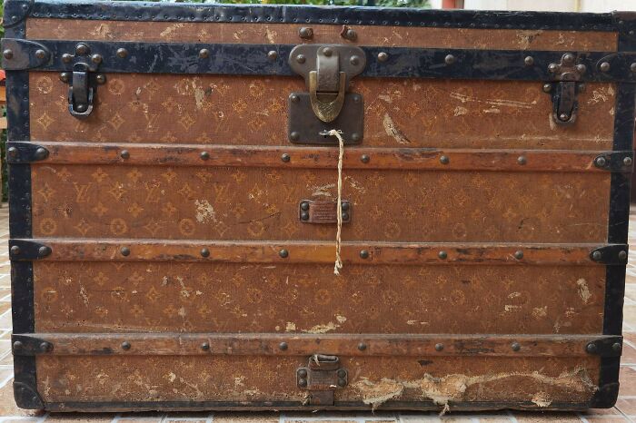 A weathered brown Louis Vuitton trunk with metal accents and a worn latch, showcasing the true value of an unusual possession.