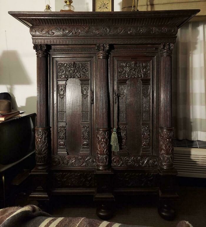 An ornate, dark wood cabinet with intricate carvings and columns, highlighting the unusual possessions and their true value.