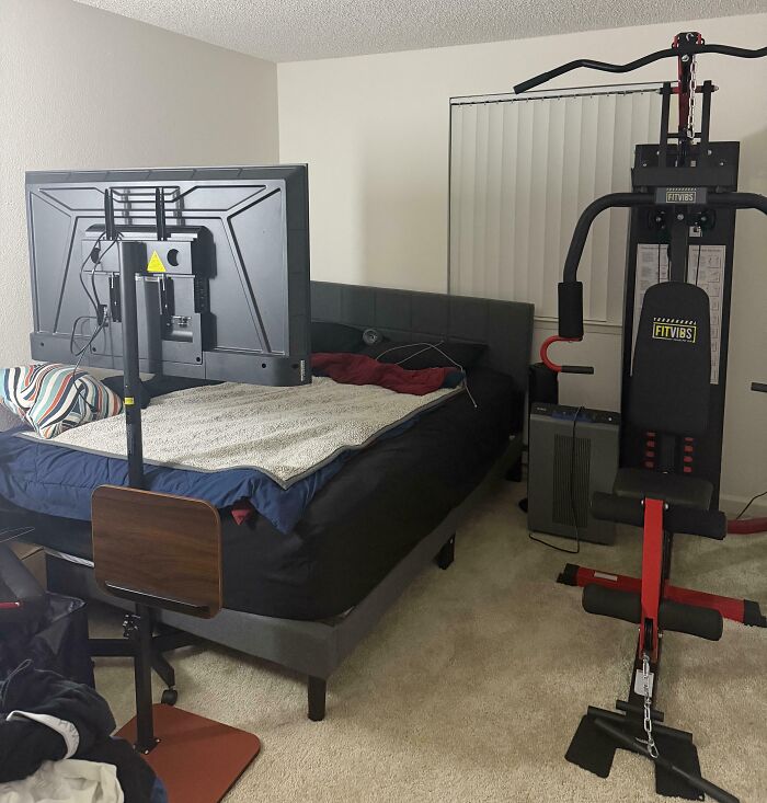 A bedroom with a bed, TV on a stand, and a multi-station home gym. It reflects a possible bank account red flag.