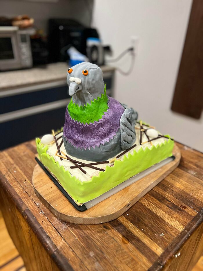 Colorful bird shaped cake decorated with green and purple frosting
