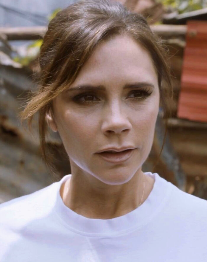 Victoria Beckham outdoors, wearing a white top, with a focused expression highlighting her bio and career.
