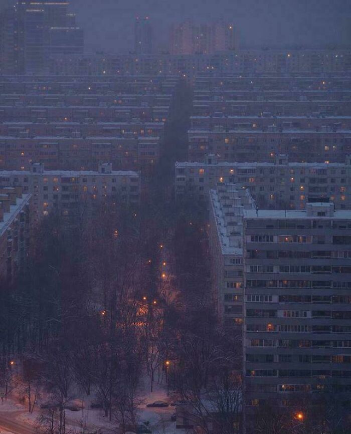 Dusk view of large apartment blocks with faint lights in urban hell