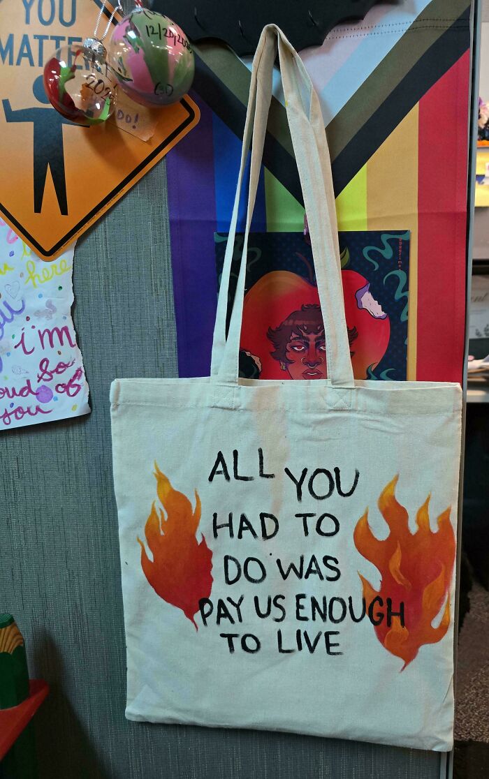 A handmade tote bag with flames and text ALL YOU HAD TO DO WAS PAY US ENOUGH TO LIVE, a unique project.