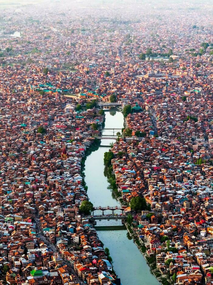 Dense urban sprawl with river cutting through cityscape in urban hell