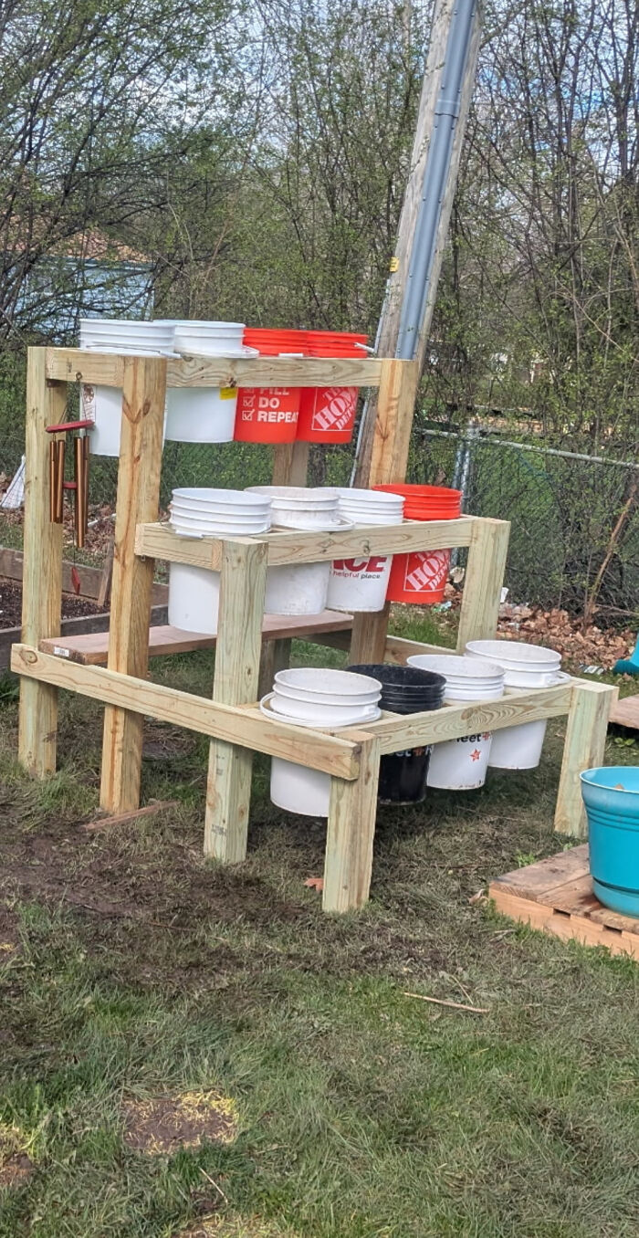 Clever solution: Buckets as planters on a wooden stand for gardening with random junk.