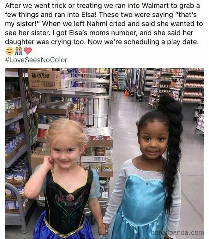 Two young girls dressed as Elsa holding hands in a Walmart aisle, sharing a heartwarming moment of positivity.