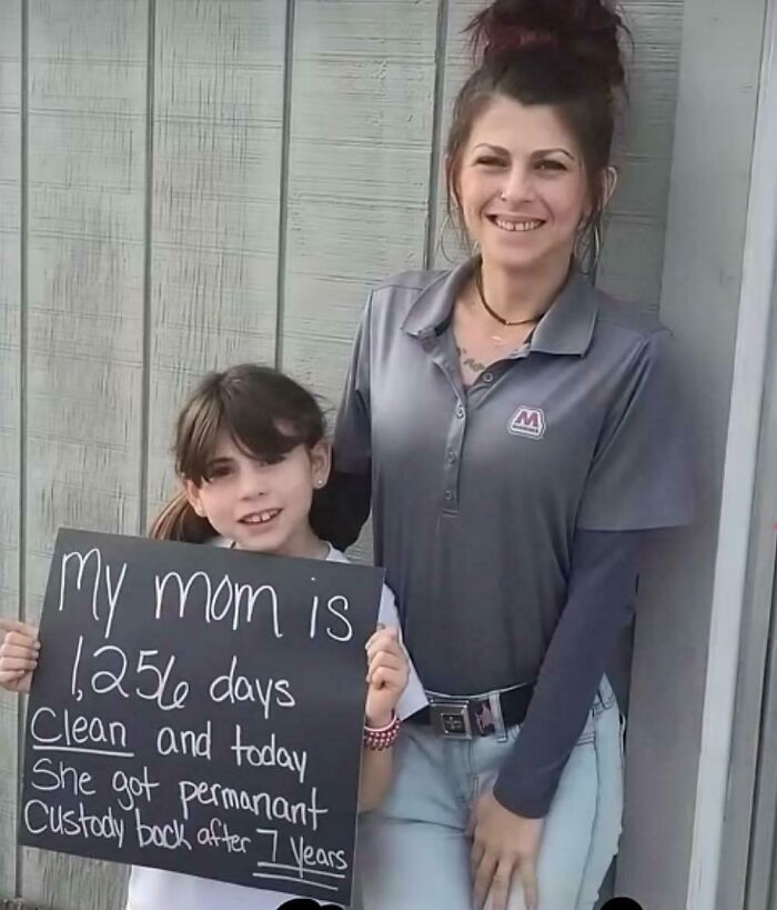 Young girl holding a positive message about her mom's recovery and custody, inspiring heartwarming posts for much-needed positivity.