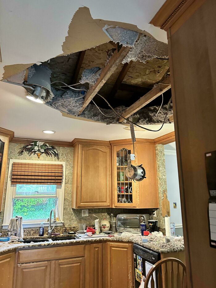 A collapsed kitchen ceiling with debris covering the counters below, a true home improvement fail. Concrete debris is visible.