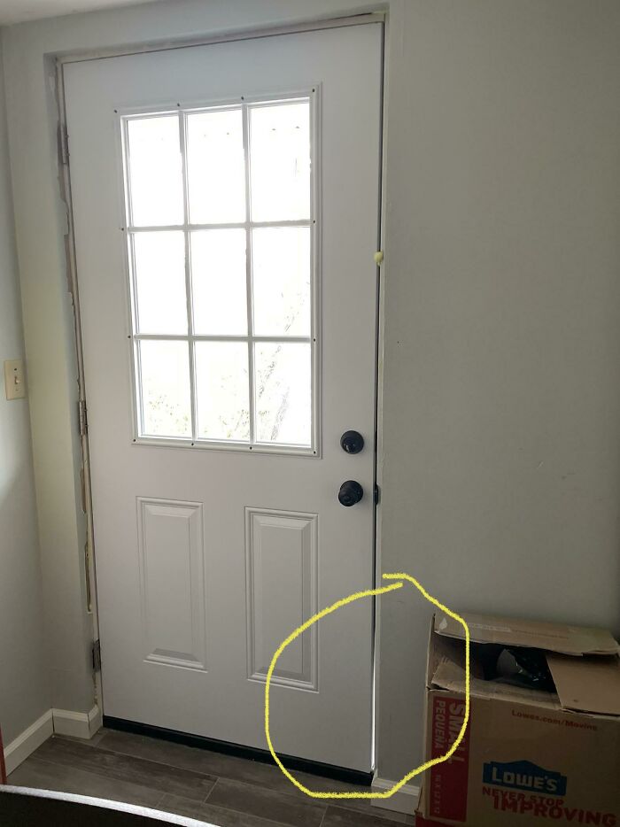 A white door with a window, part of a home improvement fail. The yellow circle highlights a large gap.