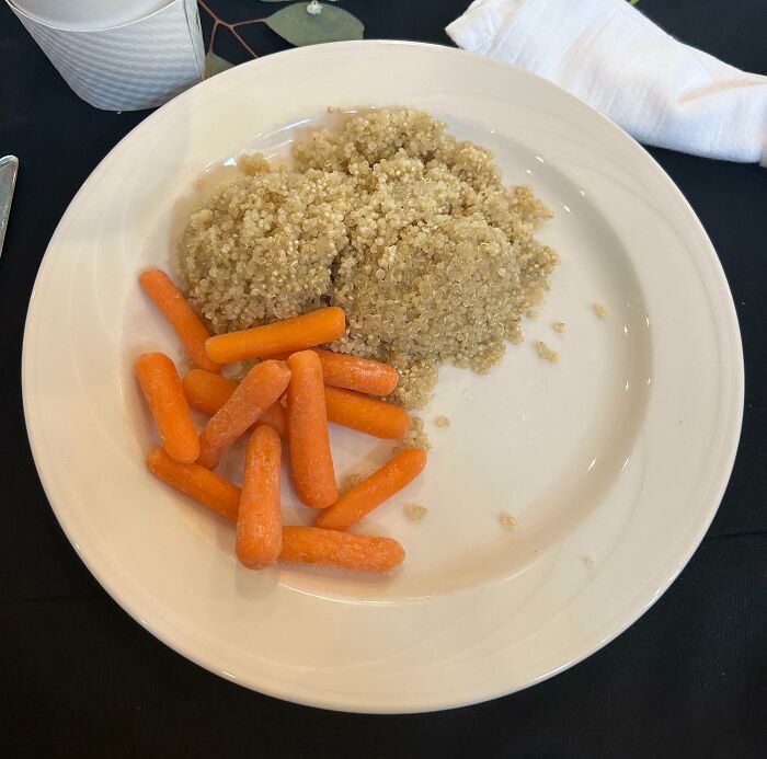 A white plate with a pile of quinoa and baby carrots, a Food Crime.