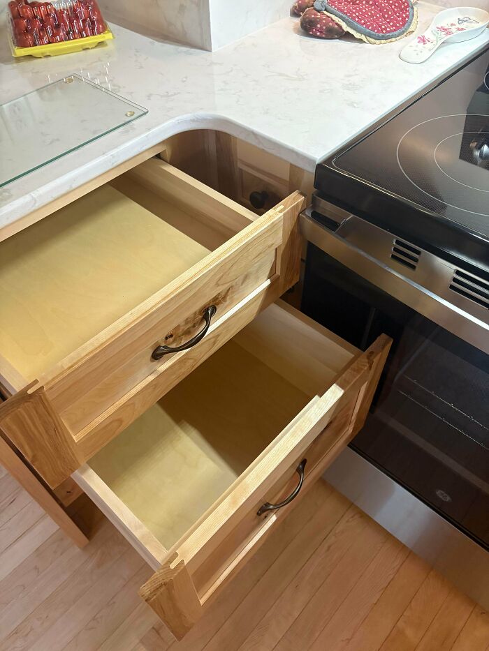 Open kitchen drawers next to a stove, illustrating a home improvement fail due to poor planning or installation.