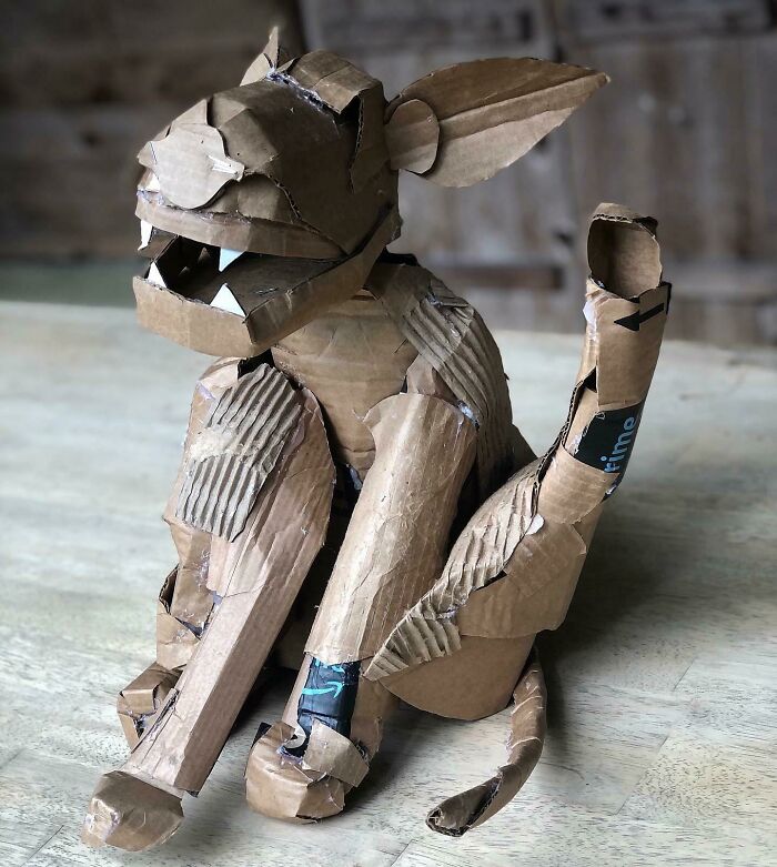 A cardboard creature, resembling a gargoyle or mythical animal, crafted from creative trash like Amazon Prime boxes. Surprisingly artistic.