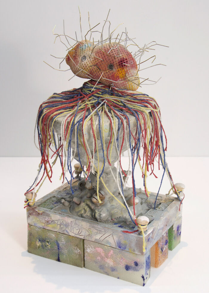 Creative people turned trash into a sculptural artwork with colorful threads, wires, and painted elements.
