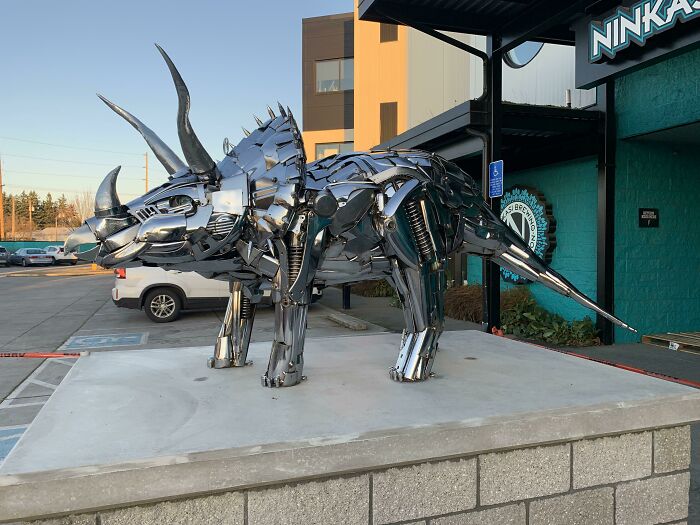 A giant metallic triceratops sculpture made from trash, showcasing how creative people turned trash into something artistic.