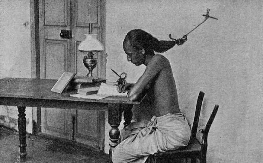 Fascinating photo of a man studying, his hair tied to a hook to prevent sleeping. A unique history lesson.