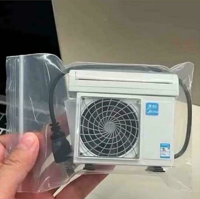 A hand holds a miniature air conditioner in plastic packaging, a common Temu or AliExpress item, illustrating a lesson learnt.