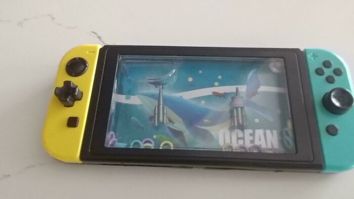 A water game toy styled like a Nintendo Switch, yellow and teal, depicting an ocean scene. A Temu AliExpress lesson learnt.