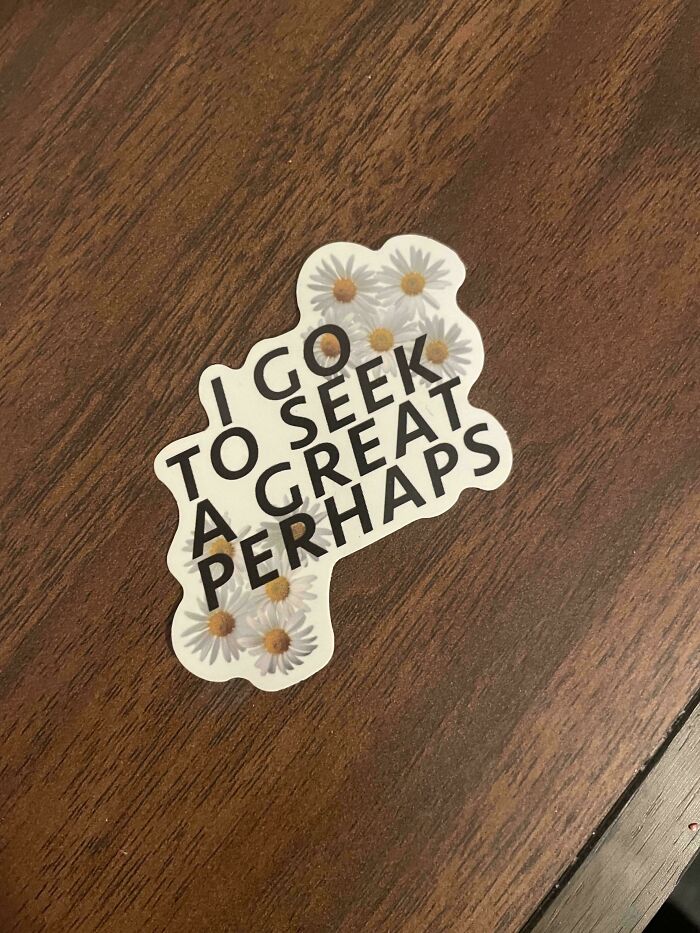 White sticker on wood with text: I GO TO SEEK A GREAT PERHAPS and daisies. A lesson learnt from Temu or AliExpress.