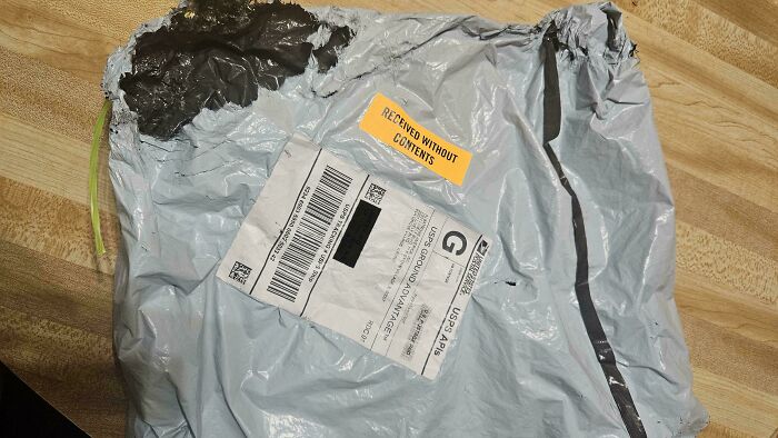 A grey polymailer, torn open & marked RECEIVED WITHOUT CONTENTS, illustrating issues when ordering from Temu or AliExpress.