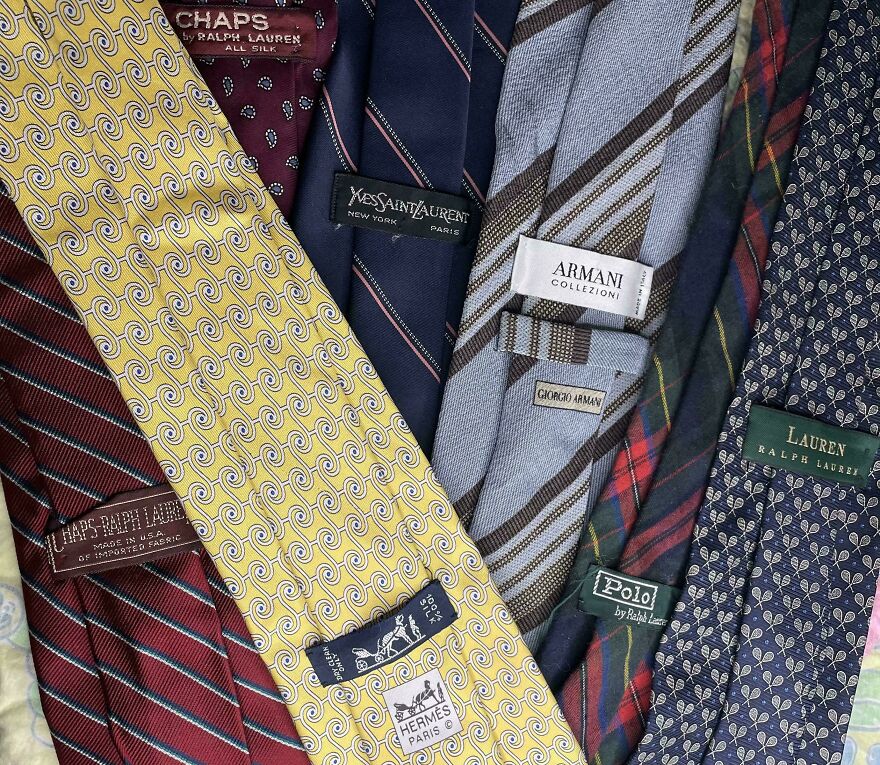 A collection of designer ties, including Hermès, Armani, and Ralph Lauren, found in Goodwill bins.