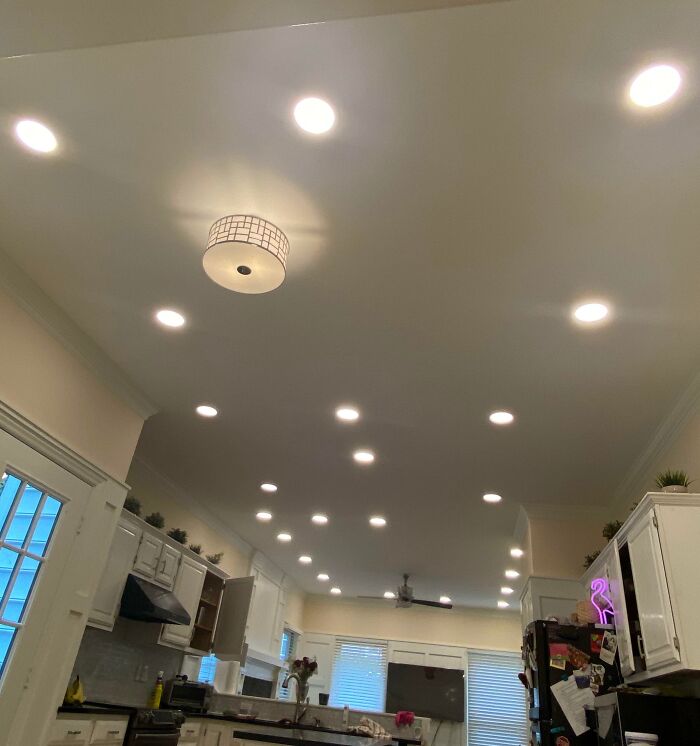Brightly lit kitchen ceiling with numerous recessed lights and a central fixture, a potential home improvement fail.