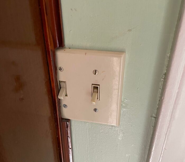 Misaligned light switch plate next to a door frame, a classic home improvement fail.