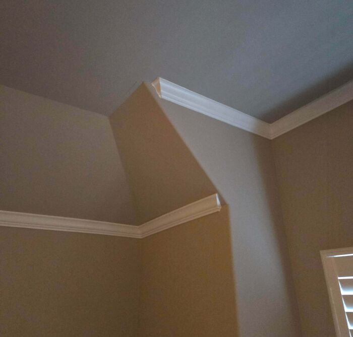 An interior corner where crown molding is cut incorrectly, showing an awkward home improvement fail.