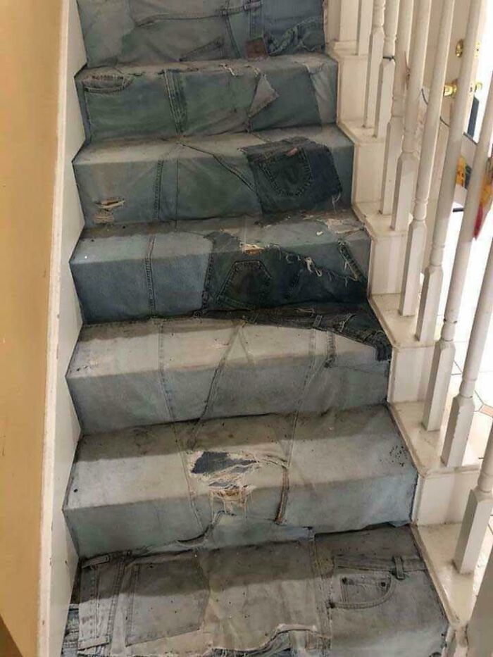 Stairs covered in various patched and distressed denim jeans, a clear home improvement fail.