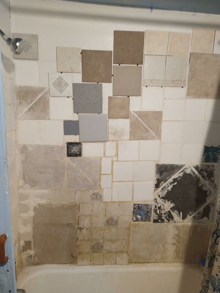 A bathroom wall with a chaotic, mismatched tile arrangement, showcasing a clear home improvement fail.