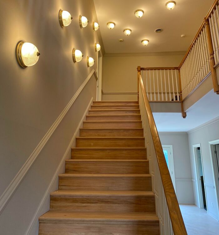 A well-lit staircase with wooden steps and a railing, hinting at a home improvement project. Home improvement fails.