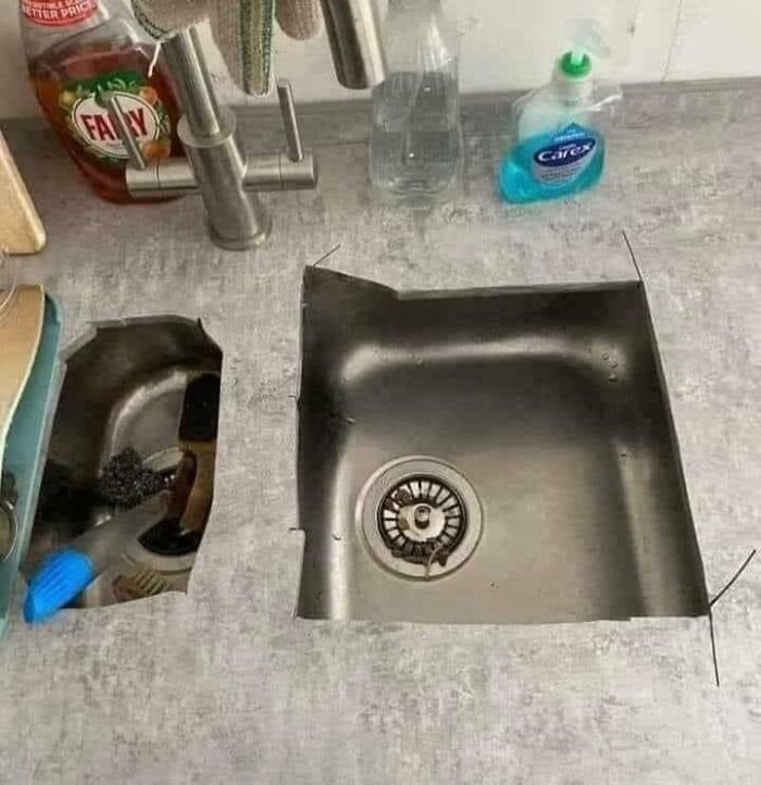 A concrete countertop with a metal sink cutout next to an opening with a blue-handled tool, a concrete fail.