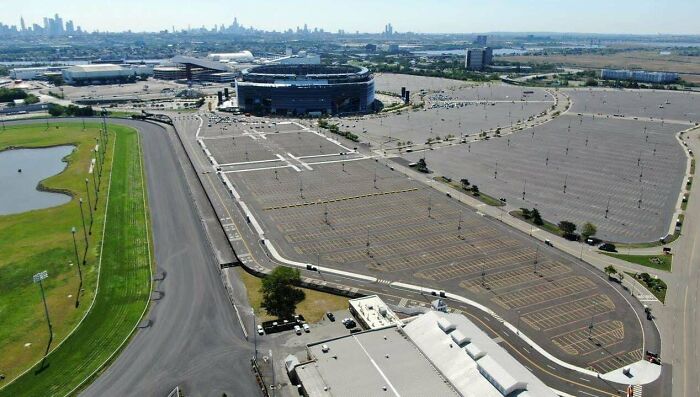 Empty parking lot near stadium in urban hell cityscape