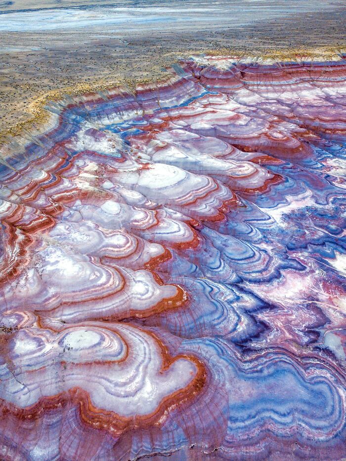 Unbelievable photos of Earth: An aerial view of colorful, striped geological formations, resembling a landscape from another universe.