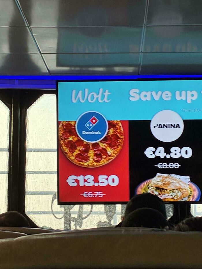 A funny fail on a digital menu board showing a Domino's pizza next to a Wolt logo and a price with a strikethrough.