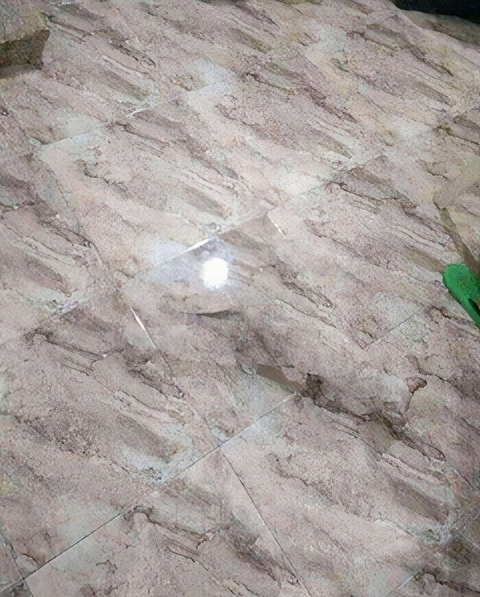 Marble floor tiles with a reflection of light creating an unusual pattern resembling devil sunrise imagery.